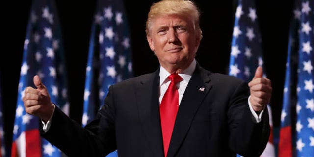 Former President Trump gives a thumbs up after speaking at an event.