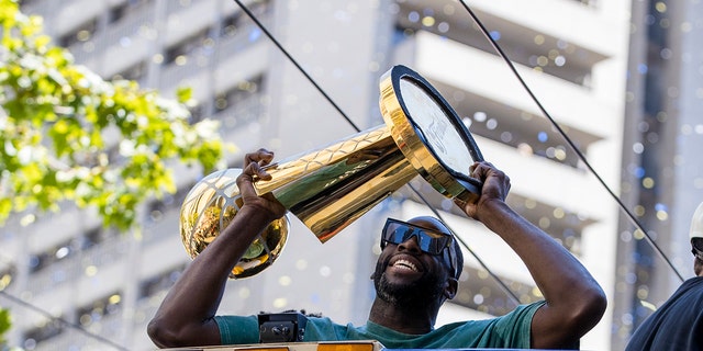 Golden State Warriors' Draymond Green holds the Larry O'Brien trophy during the NBA Championship parade in San Francisco, 星期一, 六月 20, 2022, in San Francisco. 