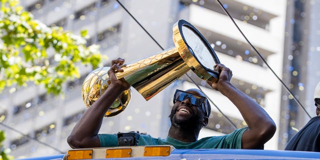 Golden State Warriors' Draymond Green holds the Larry O'Brien trophy during the NBA Championship parade in San Francisco, Monday, June 20, 2022, in San Francisco. 