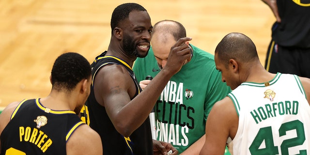 Draymond Green of the Golden State Warriors, center, reacts after colliding with Jaylen Brown of the Boston Celtics in the third quarter of Game 3 of the 2022 NBA Finals at TD Garden in Boston June 8, 2022.