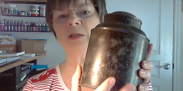 Author Pat Miller displays the type of 19th-century spice can that helped inspire the invention of the donut in 1847. Sailor Hanson Gregory used the lid of the can to cut holes in the middle of the dough balls before frying them, in order to ensure even cooking throughout. 