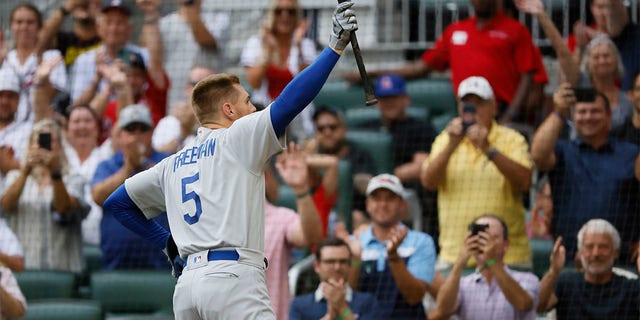 Los Angeles Dodgers' Freddie Freeman reacts to a standing ovation as he takes his first at-bat during the first inning of a baseball game against the Atlanta Braves, Sunday, June 26, 2022, in Atlanta. 