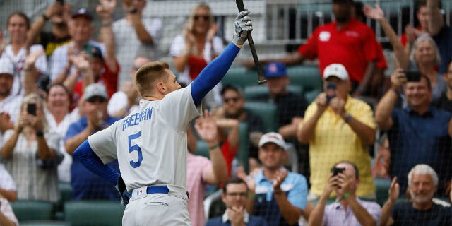 Los Angeles Dodgers' Freddie Freeman reacts to a standing ovation as he takes his first at-bat during the first inning of a baseball game against the Atlanta Braves, Sunday, June 26, 2022, in Atlanta.