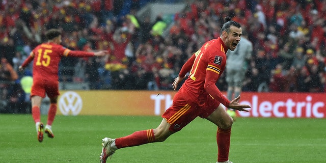 Gareth Bale, right, of Wales celebrates after scoring his side's opening goal during a World Cup 2022 qualifying playoff soccer match between Wales and Ukraine at Cardiff City Stadium, in Cardiff, Wales, June 5, 2022. 