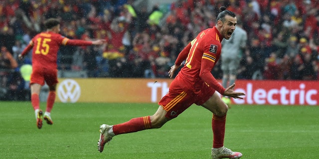 Gareth Bale, right, of Wales celebrates after scoring his side's opening goal during a World Cup 2022 qualifying playoff soccer match between Wales and Ukraine at Cardiff City Stadium, in Cardiff, Wales, June 5, 2022. 