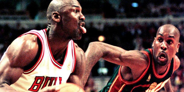 Michael Jordan of the Chicago Bulls looks to make a basket as Seattle SuperSonics guard Gary Payton defends in the fourth quarter of the 18 March game in 1997 at the United Center in Chicago, Illinois.