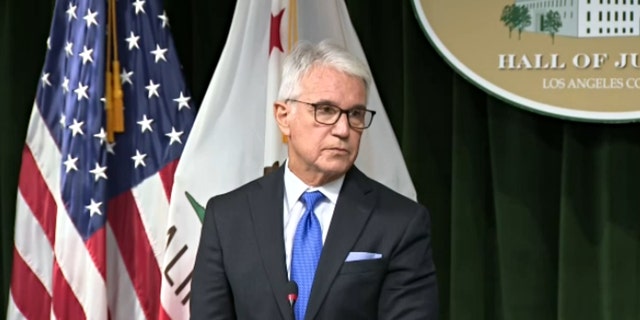 Los Angeles District Attorney George Gascon frowns during a news briefing.