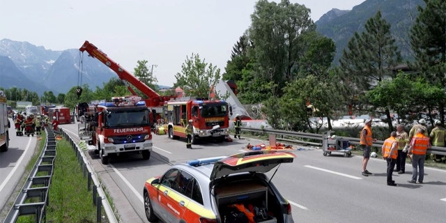 This video grab shows firemen and rescue helpers working next to a derailed train on June 3, 2022, in Burgrain near Garmisch-Partenkirchen, southern Germany.