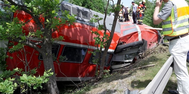 This video grab shows firemen and rescue helpers working around a derailed train on June 3, 2022, in Burgrain near Garmisch-Partenkirchen, southern Germany.