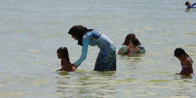 Muslim woman in a burkini enjoys the warm waters of the Gulf of Mexico at San Marco Beach on Marco Island, Florida, September 1, 2018.
