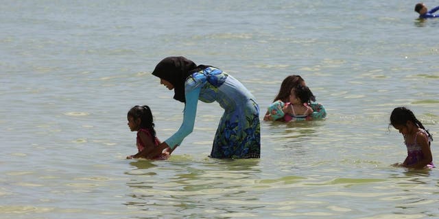 Una mujer musulmana viste un burkini mientras disfruta de las cálidas aguas del Golfo de México en la playa de San Marco en Marco Island, Florida, el 1 de septiembre de 2018. 