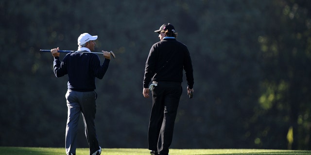 Phil Mickelson (R) walks alongside Fred Couples during a practice round prior to the 2011 Masters Tournament at Augusta National Golf Club on April 6, 2011 in Augusta, Georgia.  