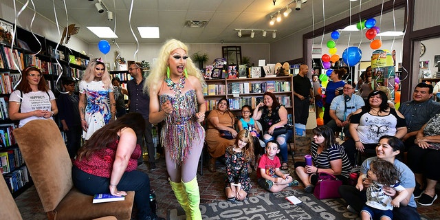 Drag queens Athena Kills (C) and Scalene Onixxx arrive to awaiting adults and children for Drag Queen Story Hour at Cellar Door Books in Riverside, California on June 22, 2019.