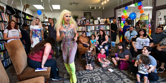 Drag queens Athena Kills (C) and Scalene Onixxx arrive to awaiting adults and children for Drag Queen Story Hour at Cellar Door Books in Riverside, California on June 22, 2019.