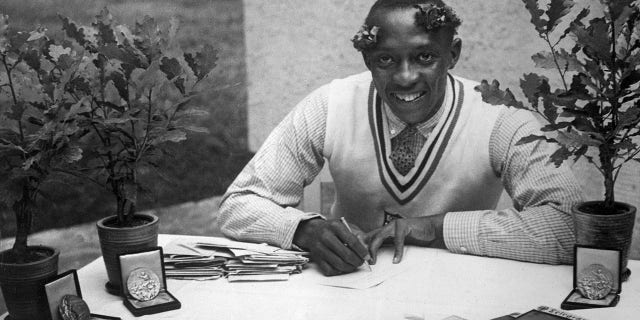 U.S. champion Jesse Owens signs autographs in August 1936 during the Olympic Games in Berlin, where he captured four gold medals — 100m, 200m, 4x100m and long jump. Grandson of a slave and legendary athlete, Jesse Owens established six world records in 1935.
