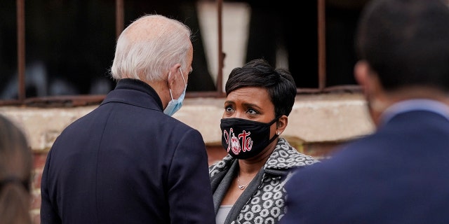 President-elect Joe Biden talks with Atlanta Mayor Keisha Lance Bottoms after a drive-in rally for U.S. Senate candidates Jon Ossoff and Rev. Raphael Warnock at Pullman Yard on Dec. 15, 2020, in Atlanta.
