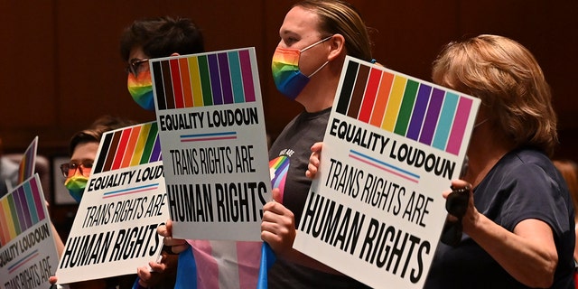 Supporters of Policy 8040 celebrate with signs as the transgender protection measures were voted into the school systems policies during a school board meeting at the Loudoun County Public Schools Administration Building on August 11, 2021, in Ashburn, Va. 