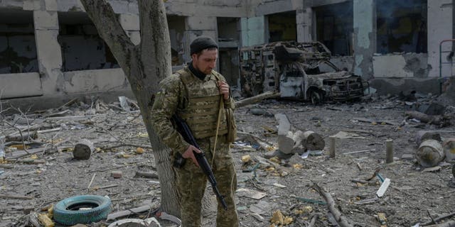 A Ukrainian soldier stands outside a school hit by Russian rockets in the southern Ukraine village of Zelenyi Hai between Kherson and Mykolaiv, less than 5km from the front line on April 1, 2022, as NATO says it is not seeing a pull-back of Russian forces in Ukraine and expects "additional offensive actions", alliance chief warns. 