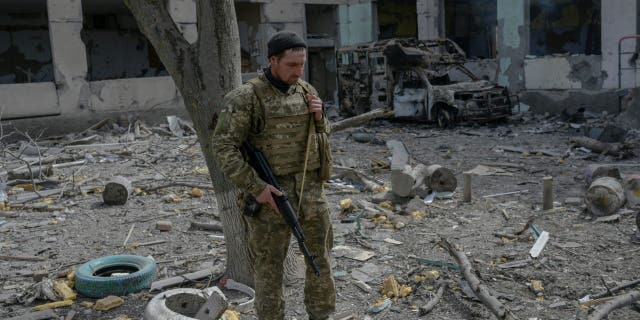 A Ukrainian soldier stands outside a school hit by Russian rockets in the southern Ukraine village of Zelenyi Hai between Kherson and Mykolaiv, less than 5km from the front line on April 1, 2022, as NATO says it is not seeing a pull-back of Russian forces in Ukraine and expects "additional offensive actions", alliance chief warns.