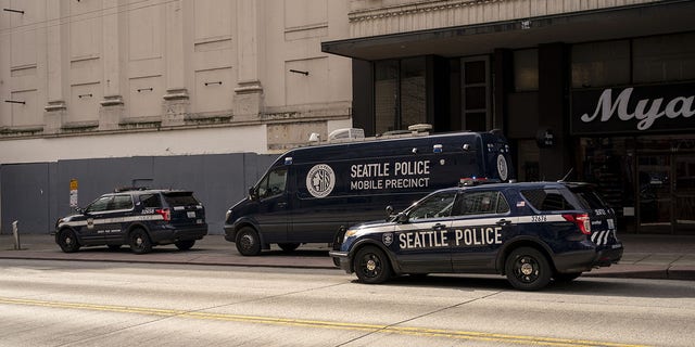 Seattle Police Department vehicles surround a mobile precinct unit on Third Avenue in downtown Seattle, Washington, U.S., on Thursday, March 24, 2022. 