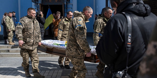 Ukrainian servicemen carry the casket bearing the remains of journalist Maks Levin  on April 4, 2022 in Kyiv, Ukraine.