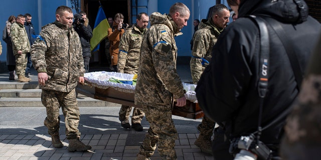 Ukrainian servicemen carry the casket bearing the remains of journalist Maks Levin  on April 4, 2022 in Kyiv, Ukraine.