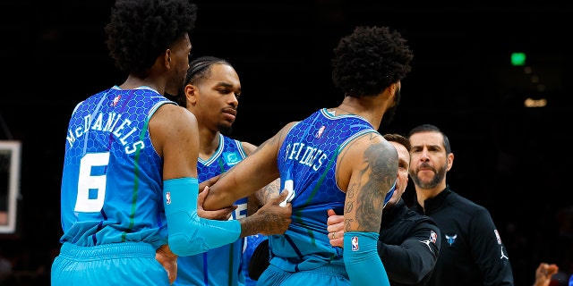 Miles Bridges #0 of the Charlotte Hornets is restrained after a foul is called and he is ejected during the second half against the Atlanta Hawks at State Farm Arena on April 13, 2022 in Atlanta, Georgia. 