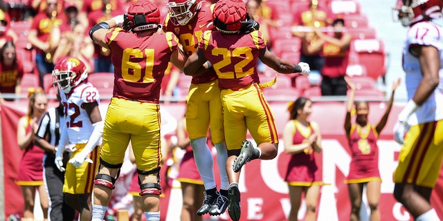 USC Trojans, from left, Joe Bryson, Kyle Ford and Darwin Barlow celebrate a touchdown on April 23, 2022, at Los Angeles Memorial Coliseum. 