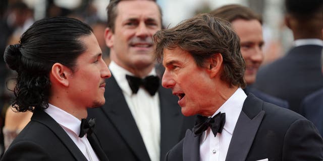 Danny Ramirez and Tom Cruise chatting as they arrive for the screening of the film "Top Gun : Maverick" during the 75th edition of the Cannes Film Festival in Cannes, southern France, on May 18, 2022.