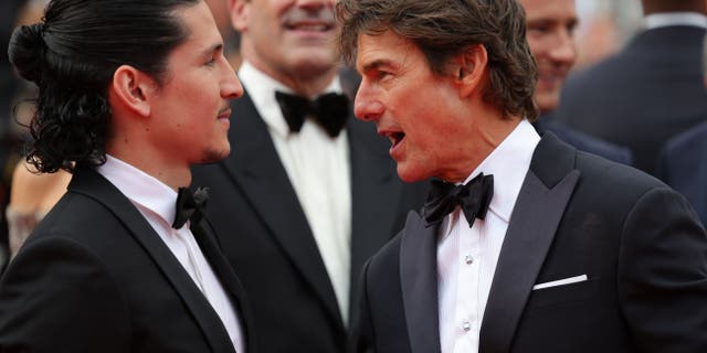 Danny Ramirez and Tom Cruise chatting as they arrive for the screening of the film "Top Gun : Maverick" during the 75th edition of the Cannes Film Festival in Cannes, southern France, on May 18, 2022.