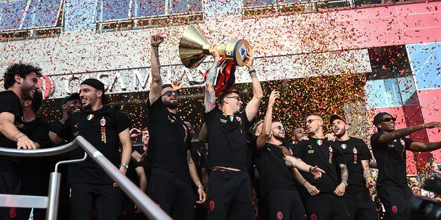 AC Milan players celebrate with the Scudetto Trophy at the club's headquarters Casa Milan in Milan on May 23, 2022.