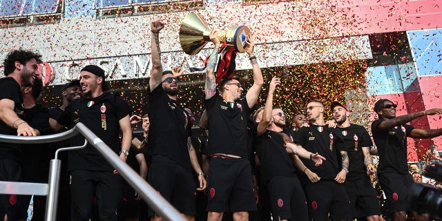 AC Milan players celebrate with the Scudetto Trophy at the club's headquarters Casa Milan in Milan on May 23, 2022.