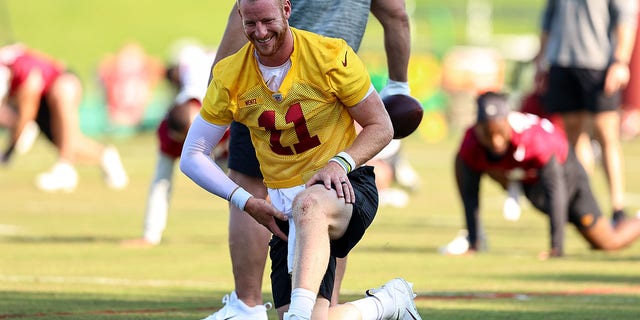 Carson Wentz (11) of the Washington Commanders stretches before the Washington Commanders' practice June 1, 2022, at the Park in Ashburn, sal. 