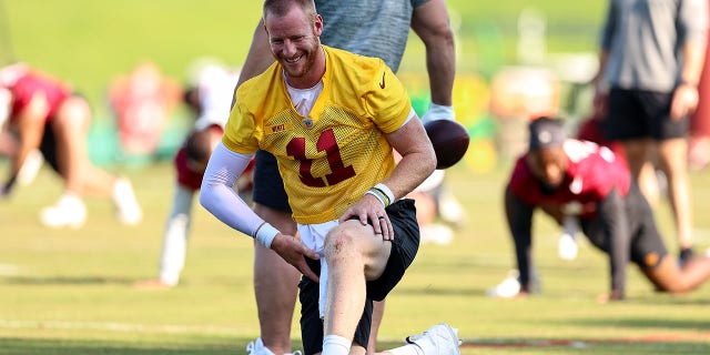 Carson Wentz (11) of the Washington Commanders stretches before the Washington Commanders' practice June 1, 2022, at the Park in Ashburn, Va.