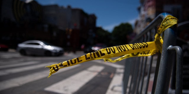 Police tape hangs from a barricade at the corner of South and 3rd Streets in Philadelphia, Pennsylvania, on June 5, 2022.