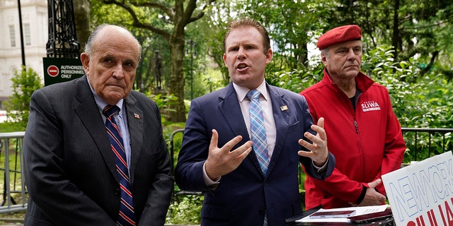 New York gubernatorial candidate Andrew Giuliani (C), with his father and former New York Mayor Rudy Giuliani (L) and Guardian Angels founder Curtis Sliwa, outlines plan to recall 'soft-on-crime' district attorneys, at City Hall Park in New York, on June 7, 2022. 