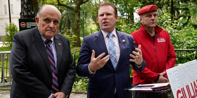 New York gubernatorial candidate Andrew Giuliani (C), with his father and former New York Mayor Rudy Giuliani (L) and Guardian Angels founder Curtis Sliwa, outlines plan to recall 'soft-on-crime' district attorneys, at City Hall Park in New York, on June 7, 2022. 