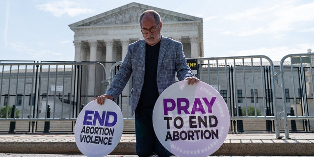 A pro-life demonstrator prays near the US Supreme Court in Washington, D.C., US, on Wednesday, June 8, 2022. 