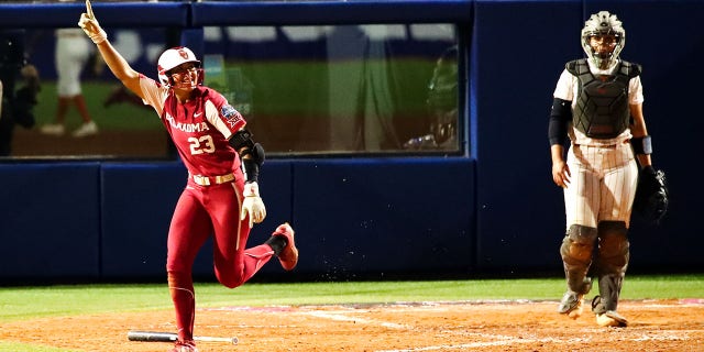 Tiare Jennings of the Sooners reacts to hitting a home run against the Texas Longhorns during the women's softball championship held at ASA Hall of Fame Stadium on June 8, 2022, in Oklahoma City.