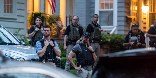 Law enforcement officers stand guard as protesters march past Supreme Court Justice Brett Kavanaugh's home on June 8, 2022 in Chevy Chase, 马里兰州. 