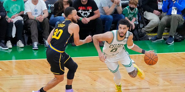 Jayson Tatum (0) of the Boston Celtics dribbles around Stephen Curry (30) of the Golden State Warriors during Game 4 of the 2022 NBA Finals June 10, 2022, at TD Garden in Boston. 