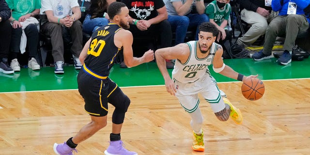 Jayson Tatum (0) of the Boston Celtics dribbles around Stephen Curry (30) of the Golden State Warriors during Game 4 of the 2022 NBA Finals June 10, 2022, at TD Garden in Boston. 