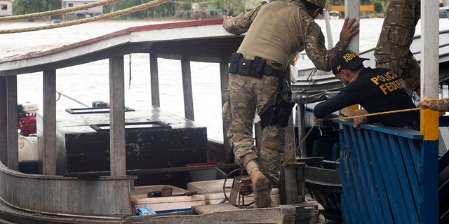 A Federal Police expert examines a boat seized by the Task Force for the rescue of Indigenist Bruno Pereira and Journalist Dom Phillips at the port of the city of Atalaia do Norte, Amazonas, Brazil, on June 11, 2022. 