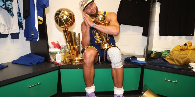 Stephen Curry de los Golden State Warriors celebra con el premio Bill Russell al Jugador Más Valioso de las Finales de la NBA después del Juego 6 de las Finales de la NBA en el TD Garden de Boston el 16 de junio de 2022.