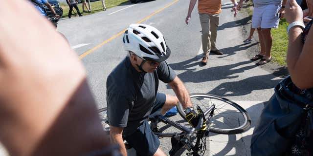TOPSHOT - US President Joe Biden falls off his bicycle as he approaches well-wishers following a bike ride at Gordon's Pond State Park in Rehoboth Beach, デラウェア, 6月に 18, 2022. - Biden took a tumble as he was riding his bicycle Saturday morning, but was unhurt. (Photo by SAUL LOEB / AFP) (ゲッティイメージズによるSAUL LOEB / AFPによる写真)