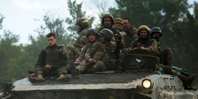 Żołnierze ukraińscy jadą w transporterze opancerzonym drogą we wschodnim obwodzie ługańskim podczas inwazji rosyjskiej na Ukrainę 23 czerwca 2022 r. 