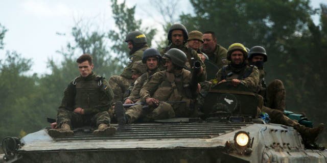 Ukrainian soldiers ride an armored personnel carrier on a road in the eastern Luhansk region on June 23, 2022, during the launch of the Russian military invasion of Ukraine. 