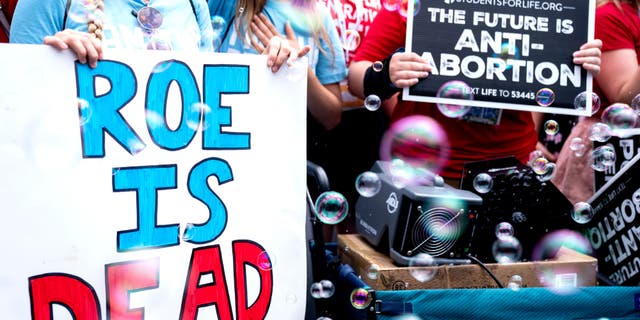 Anti-abortion activists hold signs outside the United States Supreme Court following the overturning of Roe Vs. Wade, in Washington, DC, June 24, 2022.