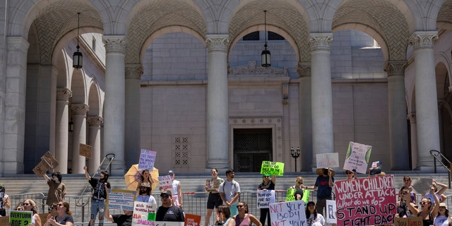 Protesters denounce the U.S. Supreme Court's decision to end abortion rights protections at the steps of City Hall. 