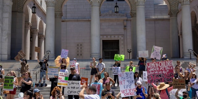 Protesters denounce the U.S. Supreme Court's decision to end abortion rights protections at the steps of City Hall.
